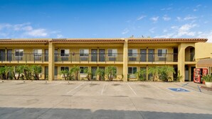 A multi-story hotel with a parking lot in front.
