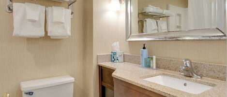 A bathroom with a toilet, sink, towel rack, and mirror.