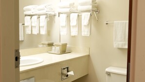 A bathroom with a sink, mirror, towel rack, and toilet. - Benny's Colville Inn (Colville)