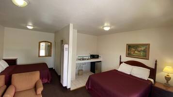 Une chambre d’hôtel avec deux lits, un bureau, une chaise, un miroir et un tableau au mur.