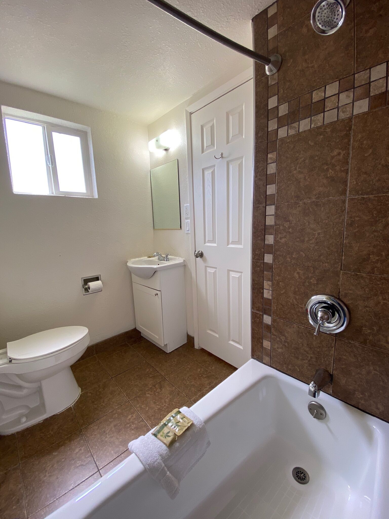Een badkamer met toilet, wastafel en bad.
