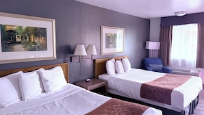 A hotel room with two beds, a desk, a chair, and two wall-mounted lamps. - Adobe Inn (Durango)