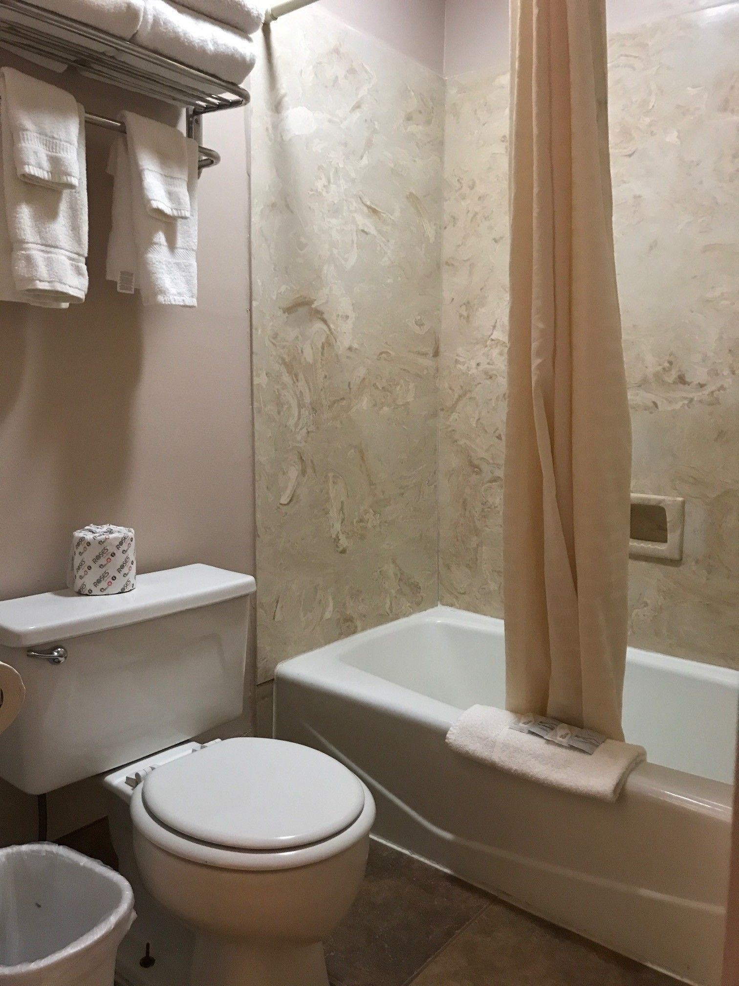 Un baño con inodoro, bañera y cortina de ducha.