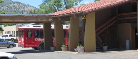 A parking area with a red bus labeled "DURAN" and a white car.