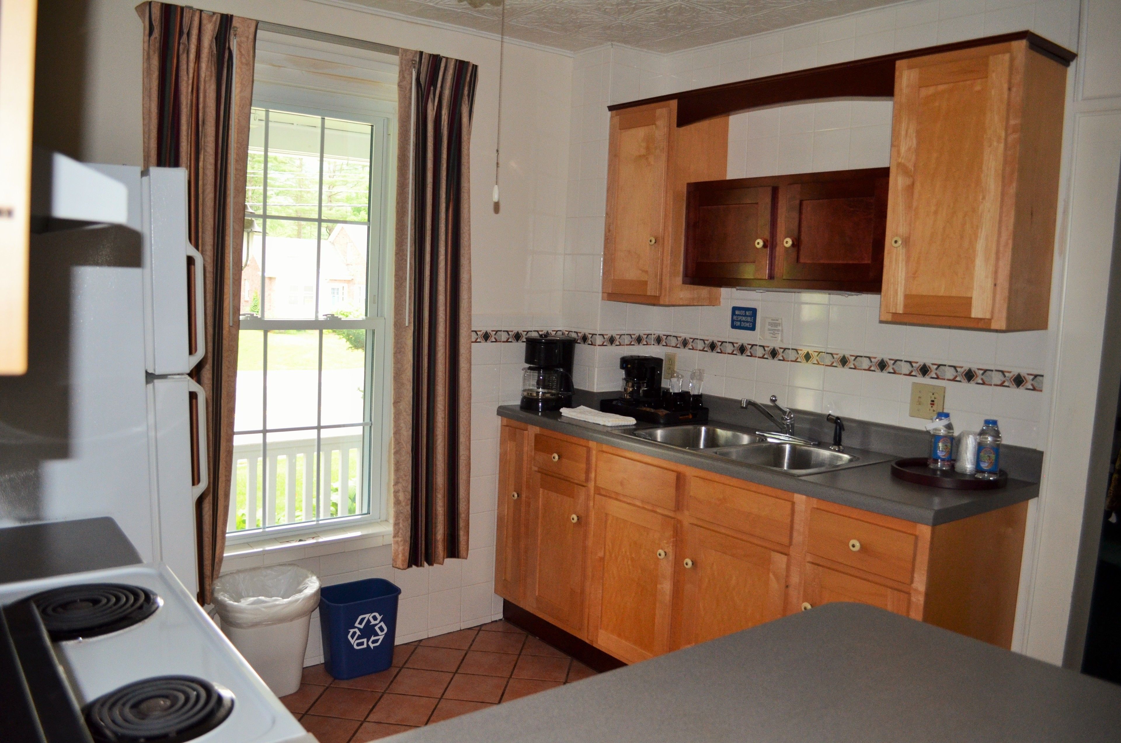 A kitchen with wooden cabinets, a sink, and a stove.