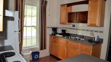 A kitchen with wooden cabinets, a sink, and a stove.