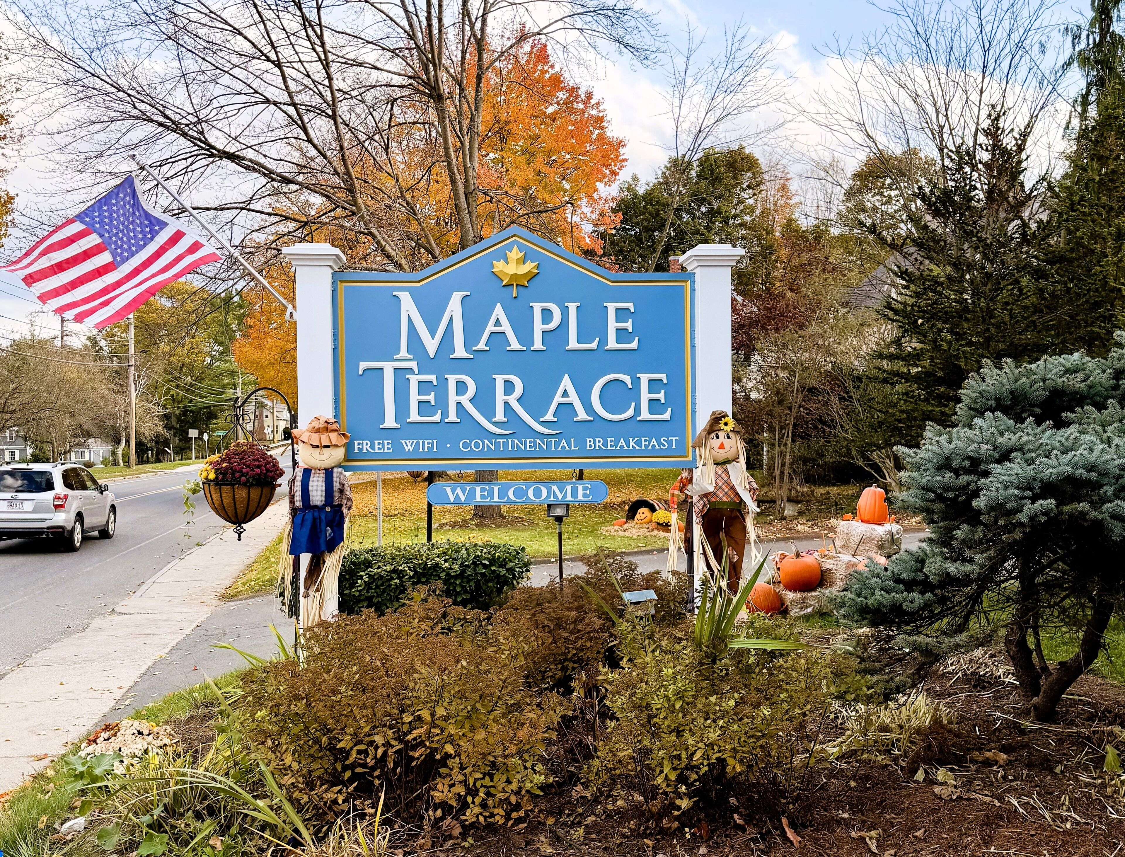 A welcome sign for Maple Terrace with amenities like free WiFi and continental breakfast.