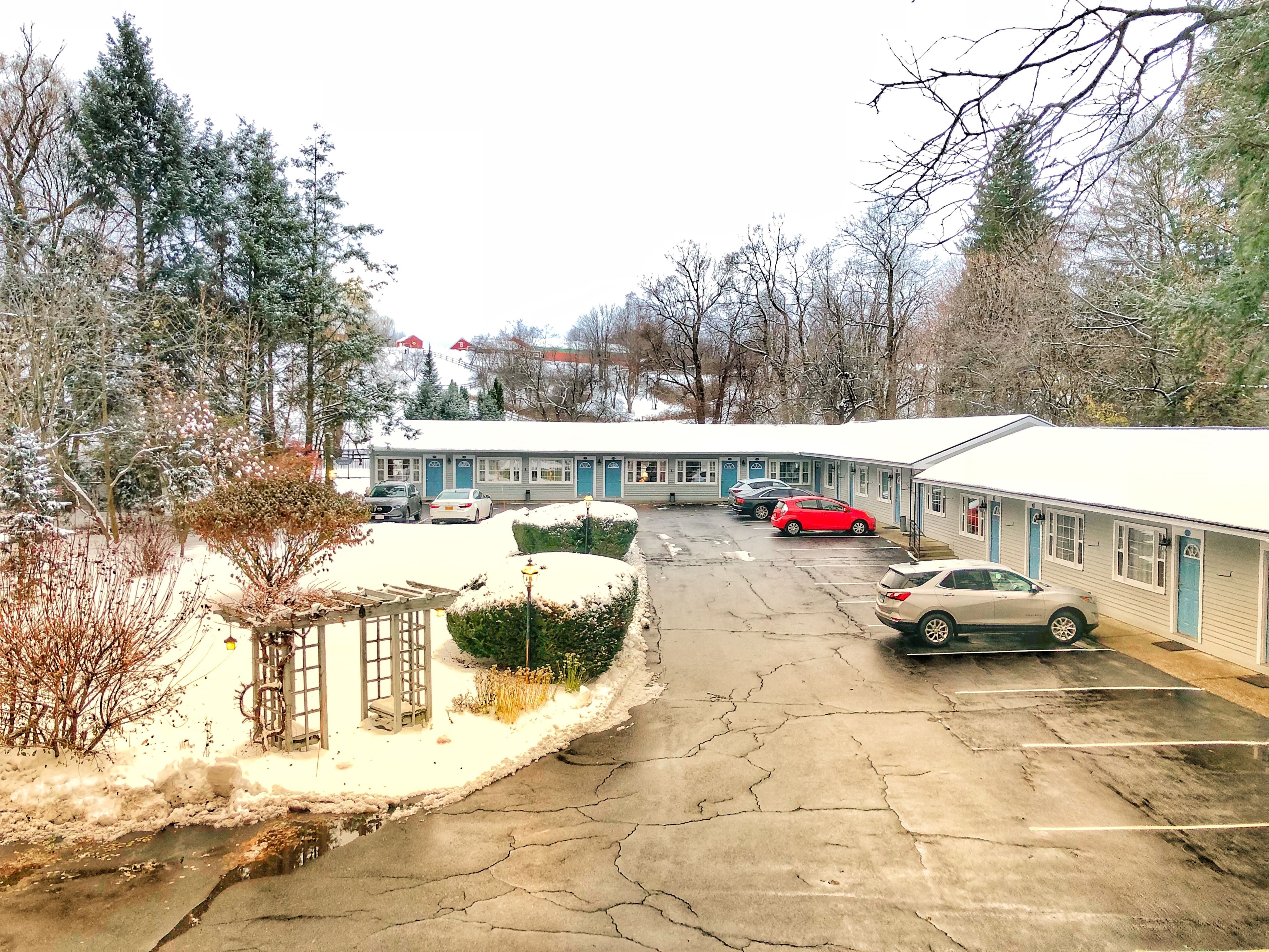 A motel with multiple rooms, a parking lot, and a snow-covered landscape.
