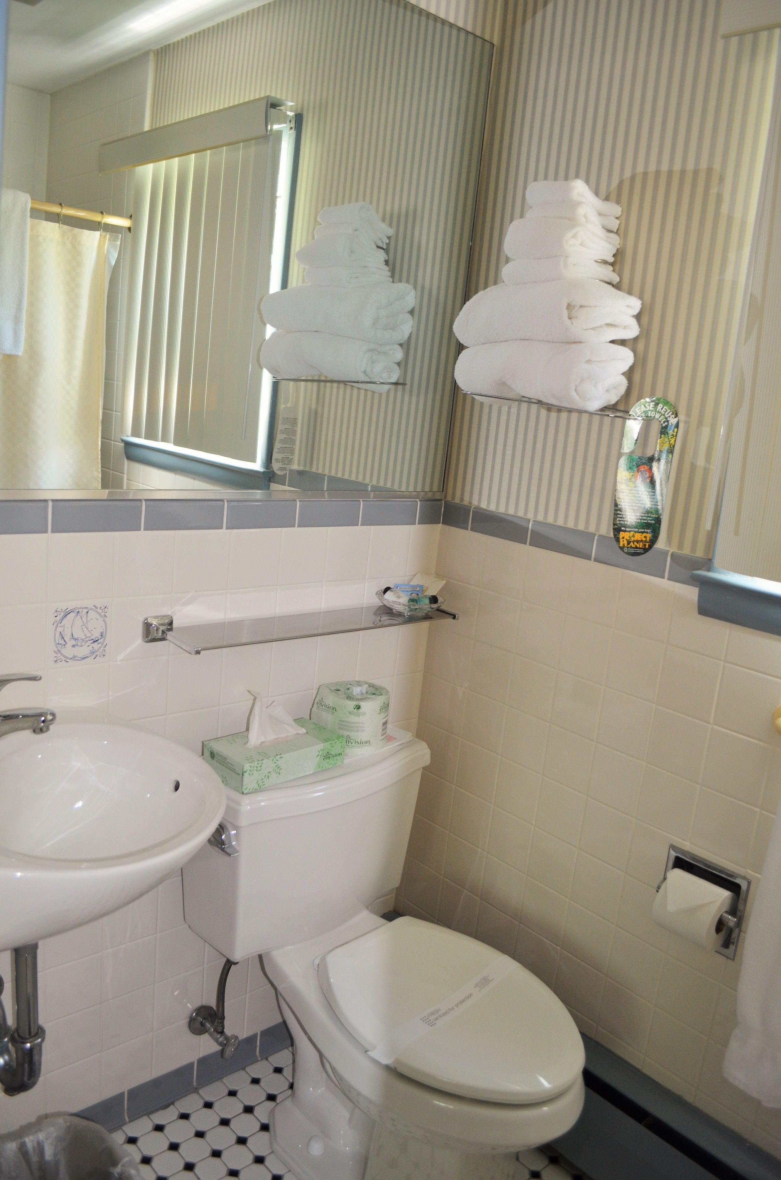 Un baño con lavamanos, inodoro y perchero para toallas.