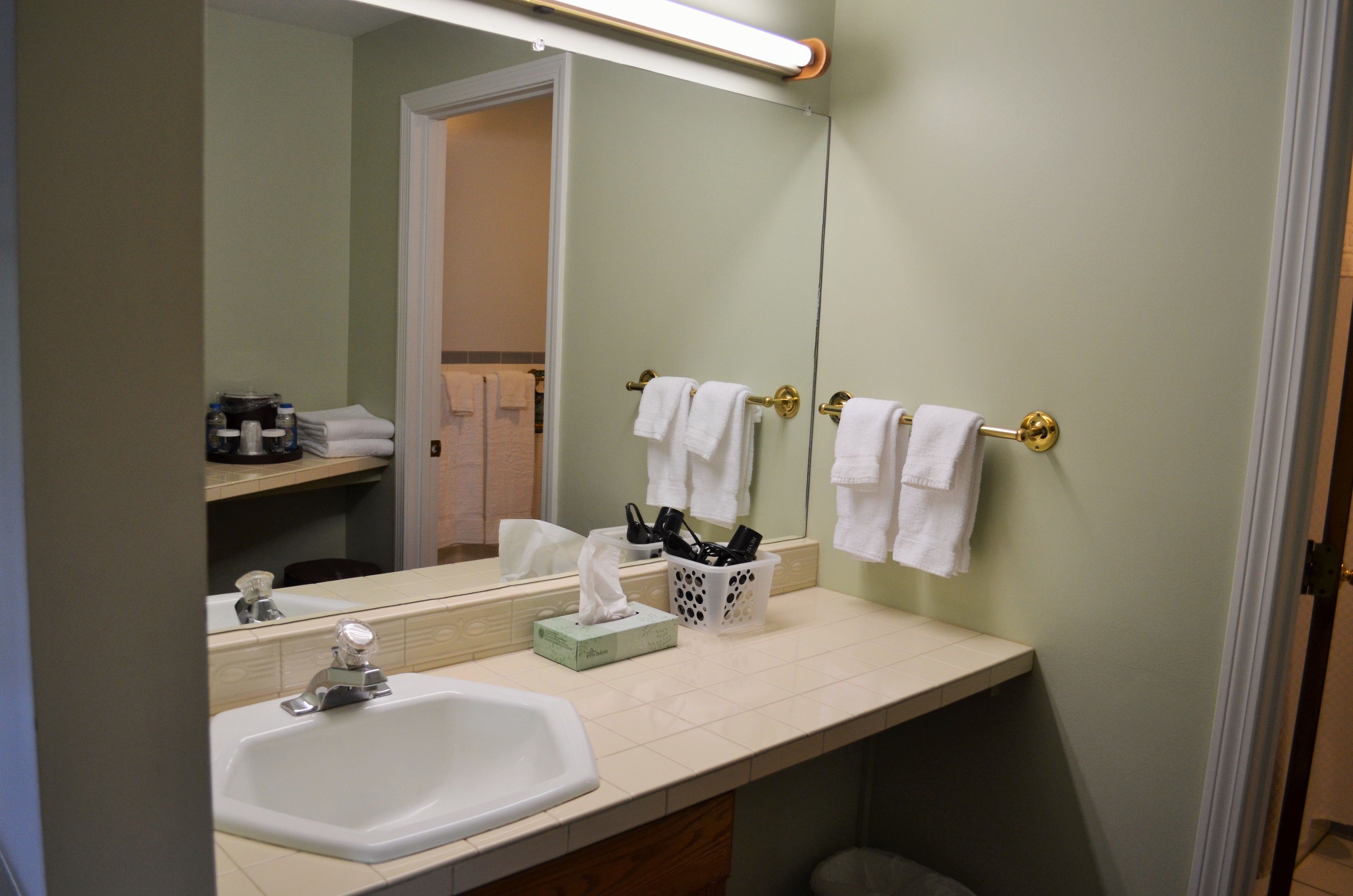A bathroom with a sink, mirror, and towel rack.