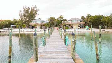 Guests can enjoy access to the beach from this resort's pier, surrounded by lush vegetation and comfortable lounge areas.