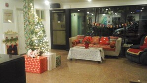 Eine Hotelhalle mit Weihnachtsbaum, einer Couch und einem Couchtisch.