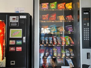 A vending machine with snacks and drinks, including Mountain Dew, Diet Coke, and Sprite. - 777 Motor INN (Huntington Beach)