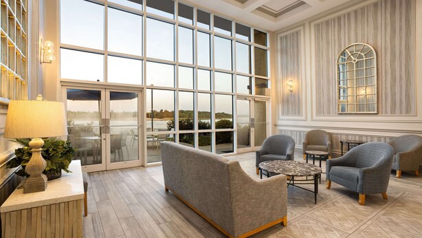 Un vestíbulo amplio con ventanas grandes, una recepción y cómodas zonas de estar.