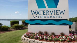 Señal del Casino & Hotel Waterview, con vista a un lago y jardín ajardinado.