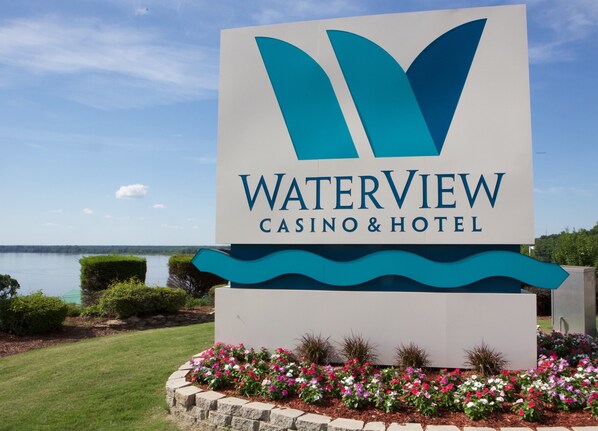 Naamplaatje voor Waterview Casino & Hotel met uitzicht op een meer en aangelegde tuin.