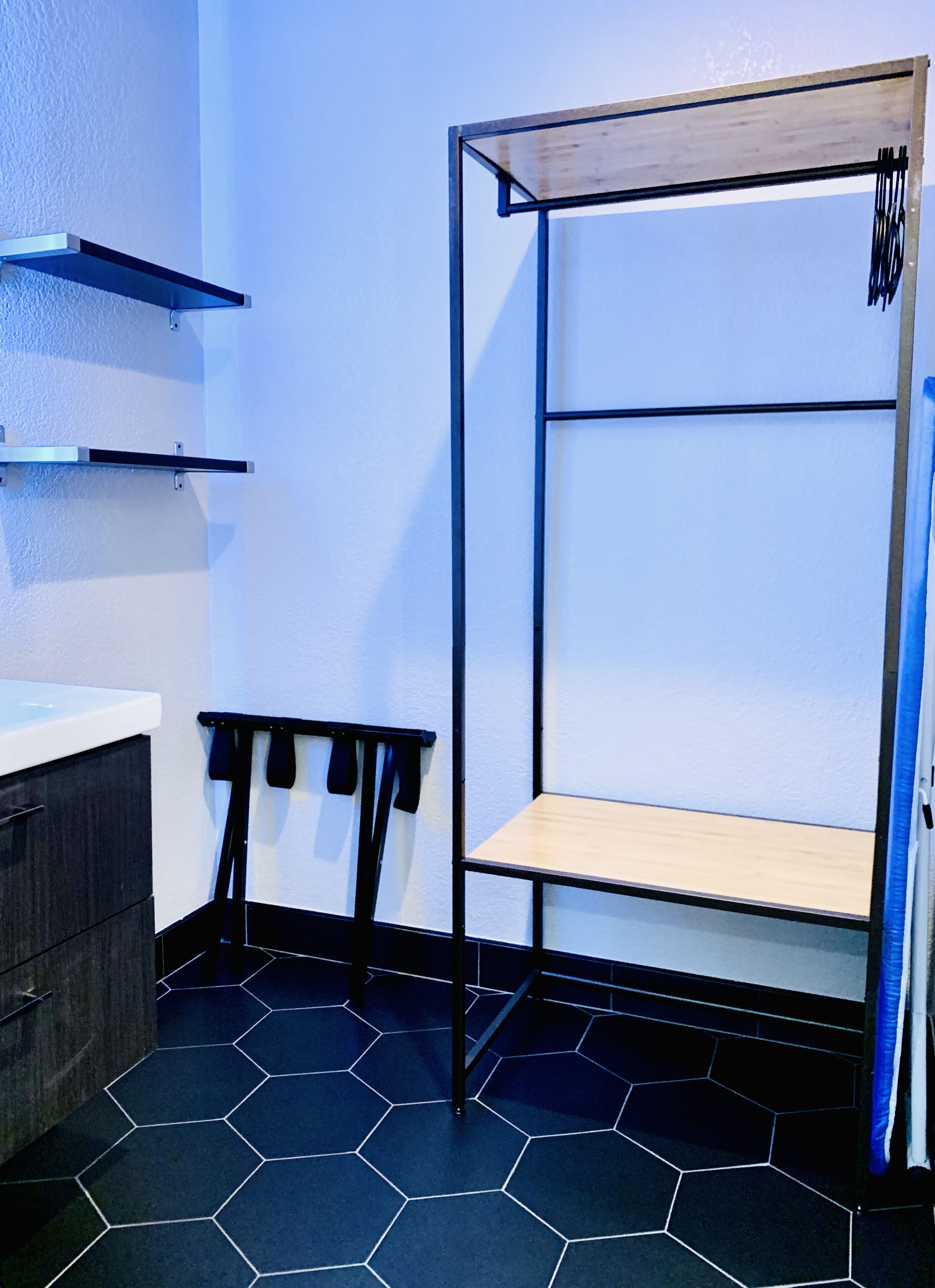 A room with a bunk bed, a small table, and a cabinet.