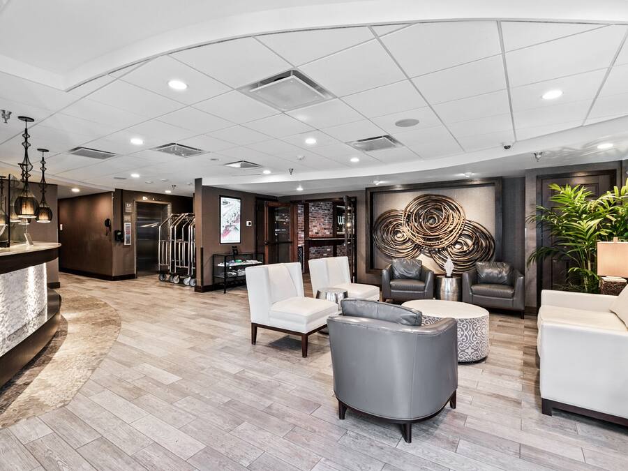 A spacious lobby with a reception desk, seating area, and a large decorative wall.