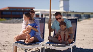 Relax on the beach with comfortable seating and shade from the umbrella.