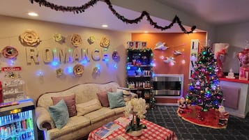 A cozy living room with a sofa, a Christmas tree, and festive decorations.