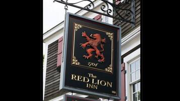Une enseigne pour l’auberge The Red Lion, avec un emblème représentant un lion rouge et le nom de l’établissement.