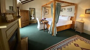 A traditional four-poster bed with a canopy, a wooden desk, a chair, a mirror, and a small bedside table with a lamp. - The Red Lion Inn Resort 1704 (Cohasset)