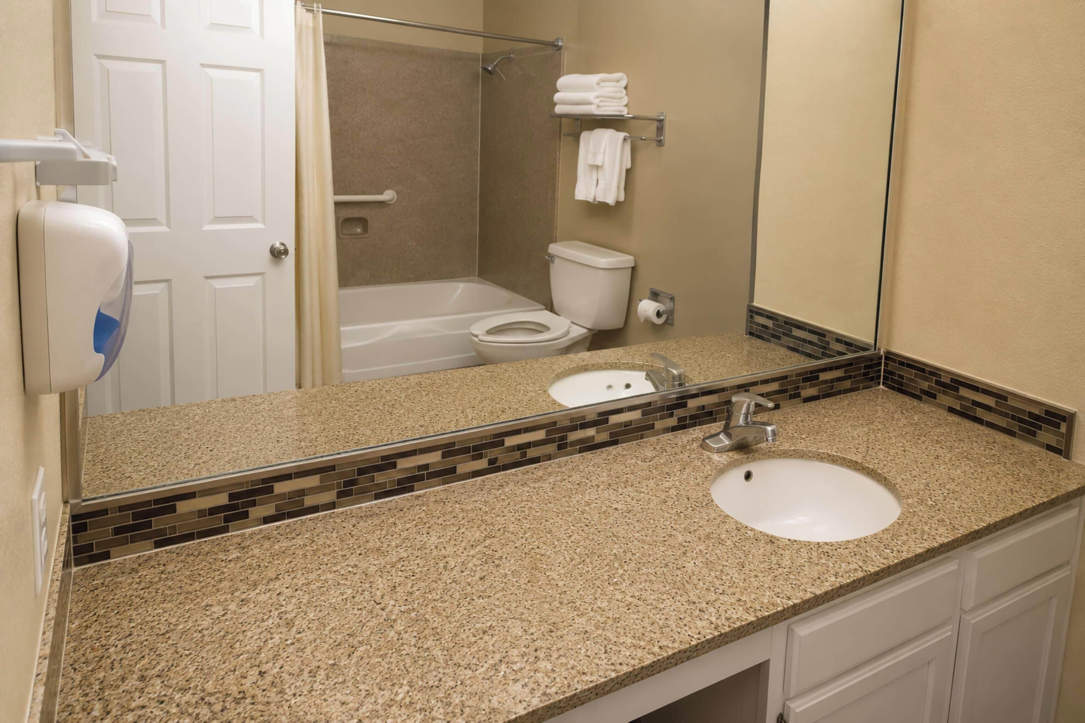 A bathroom with a sink, toilet, and shower area.