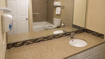 A bathroom with a sink, toilet, and shower area.