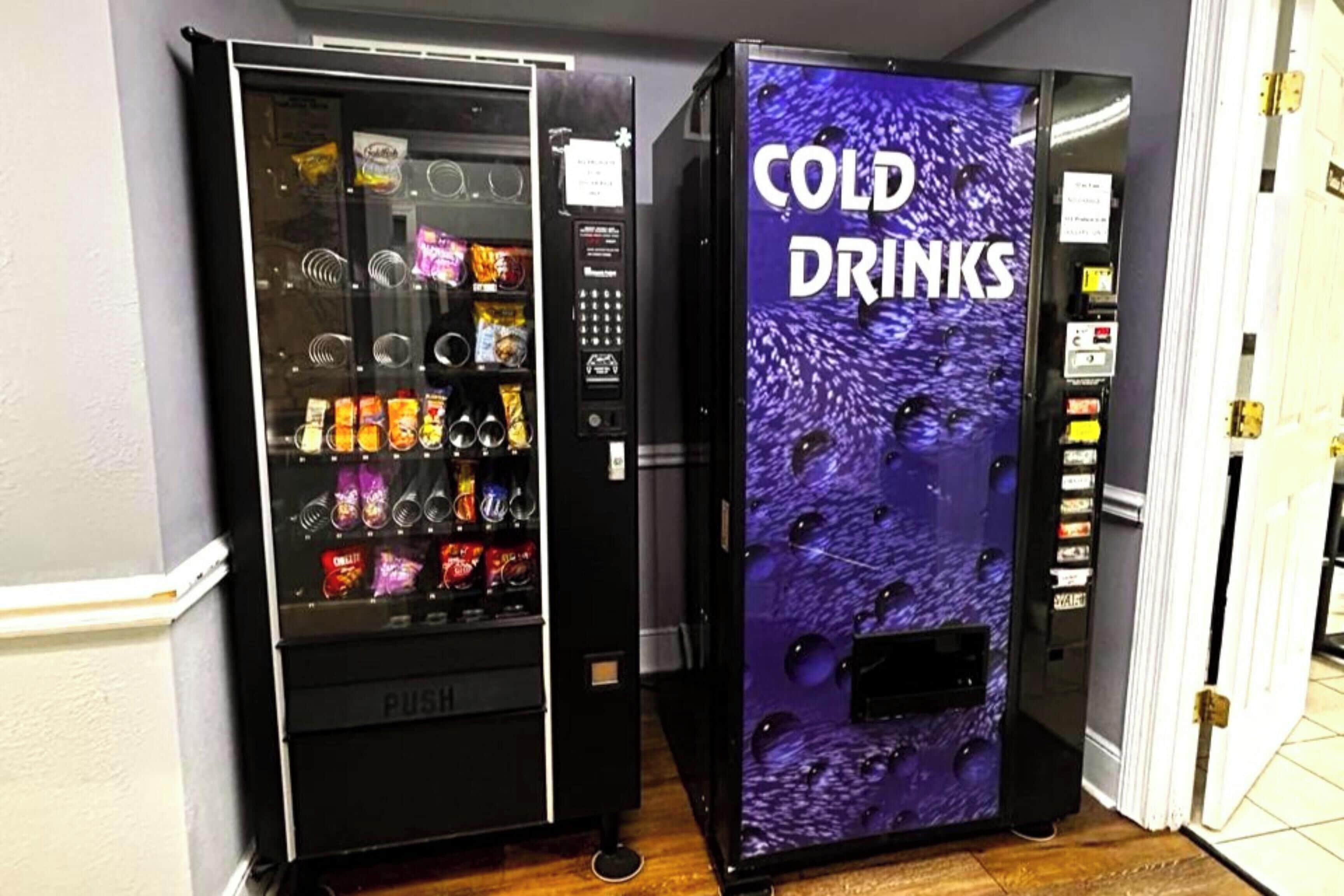 Two vending machines, one labeled 'PUSH' and the other 'COLD DRINKS,' in a hallway.