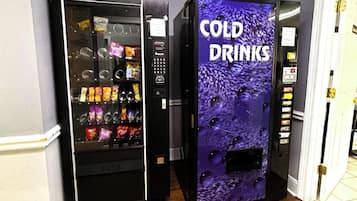 Two vending machines, one labeled 'PUSH' and the other 'COLD DRINKS,' in a hallway.