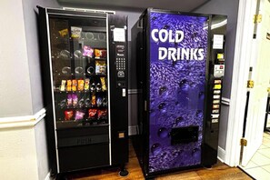 To automater, hvoraf den ene er mærket 'PUSH' og den anden 'KOLE SKIVE', står i en gang.