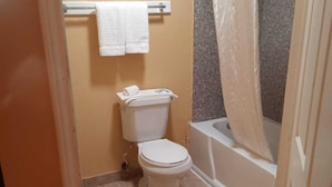 Un baño con inodoro, bañera y cortina de ducha.