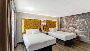 Una camera d'albergo con due letti, una parete decorata con un motivo e un murale raffigurante una scena boschiva.