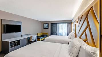 Une chambre d’hôtel avec deux lits, un bureau, un téléviseur à écran plat et un minibar.