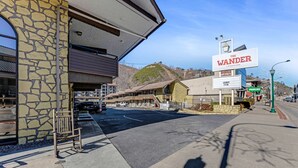 A motel with a stone facade, a sign for 'The Wander' motel, and a parking area.