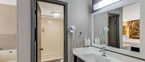 A modern bathroom with a shower, toilet, and sink.
