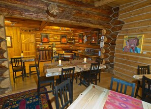 A rustic wooden interior with a dining area, wooden walls, and a bar. - Boulder Mountain Guest Ranch (Boulder)