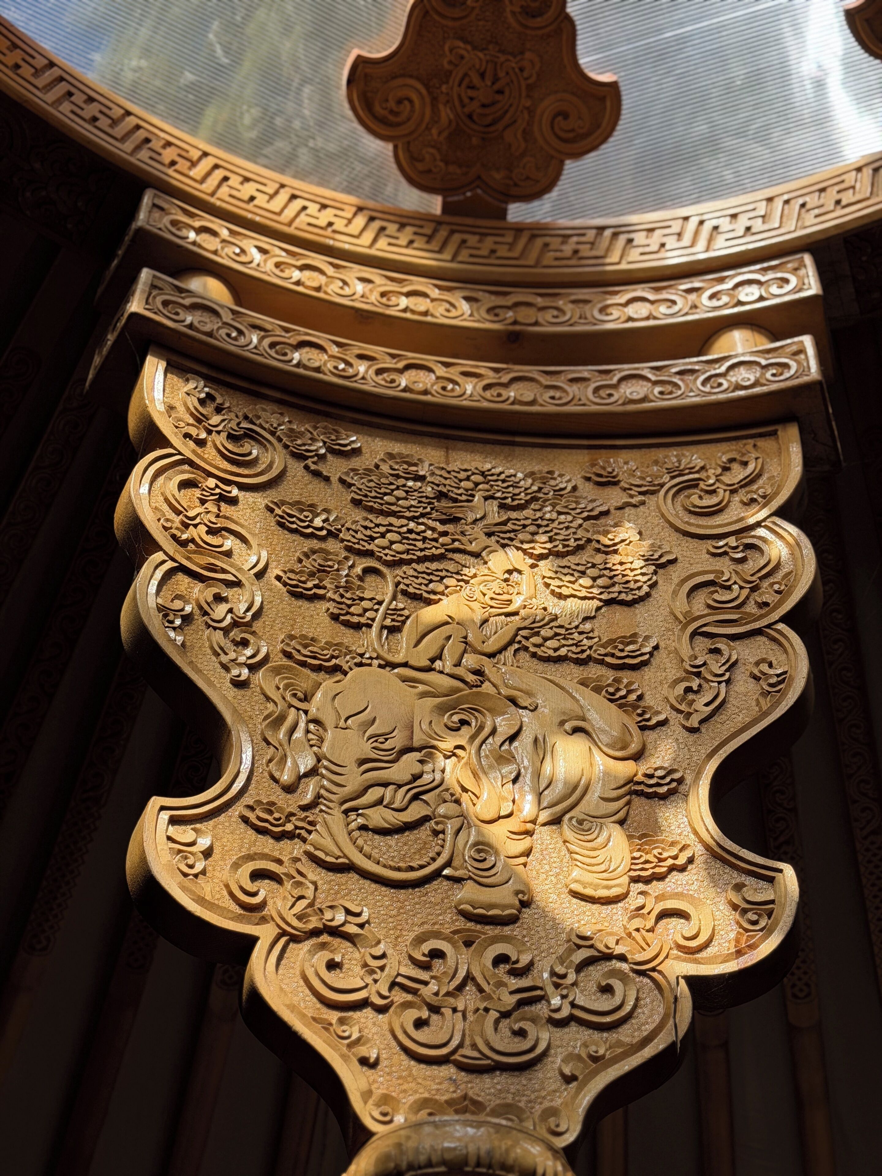A detailed golden architectural carving with intricate designs and a lion motif.