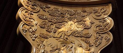 A detailed golden architectural carving with intricate designs and a lion motif.