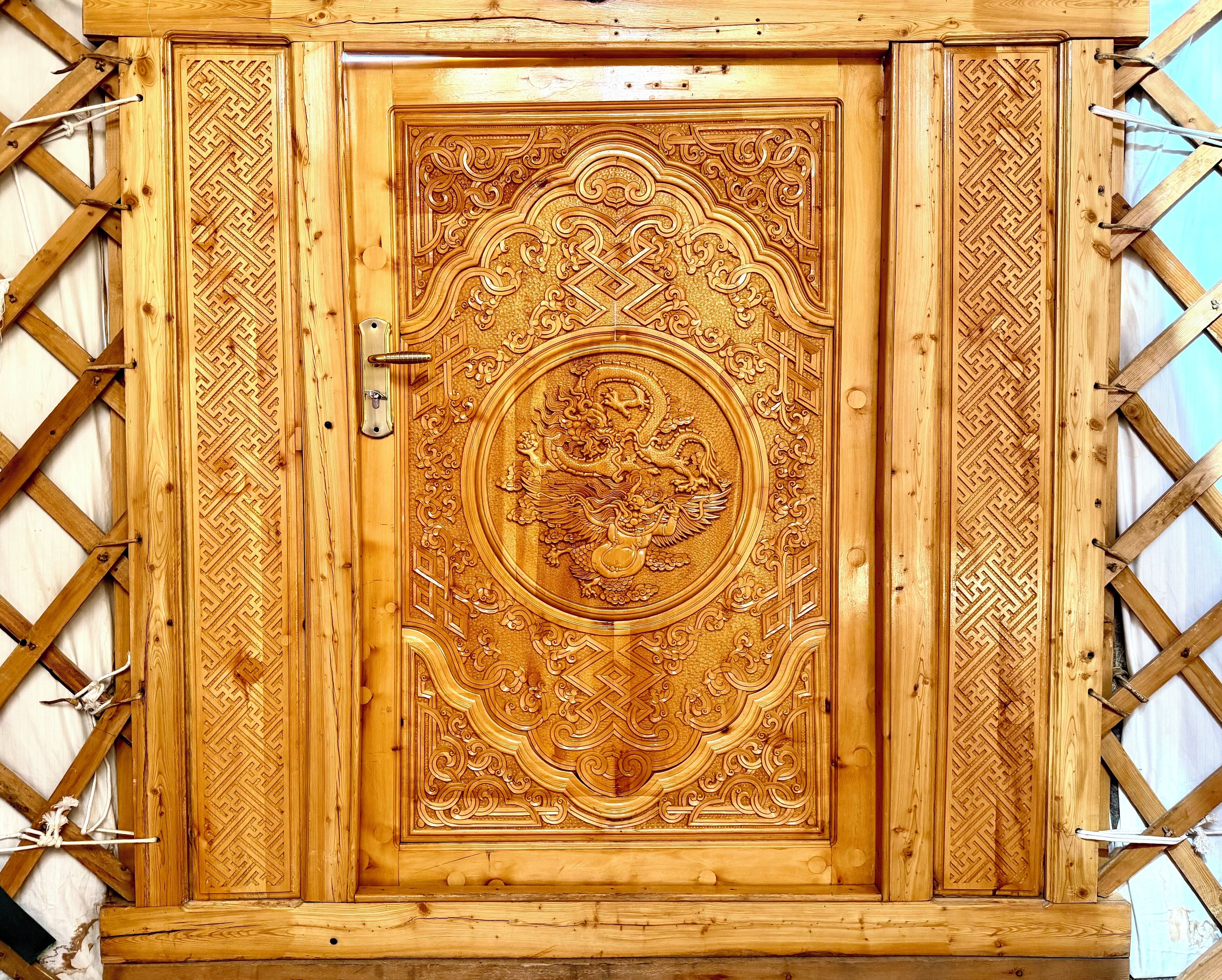 Un mueble de madera con tallas intrincadas y un motivo de dragón central.