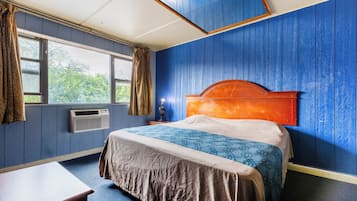 Ein Zimmer mit einem Bett, einem Schreibtisch und einem Vorhangfenster.
