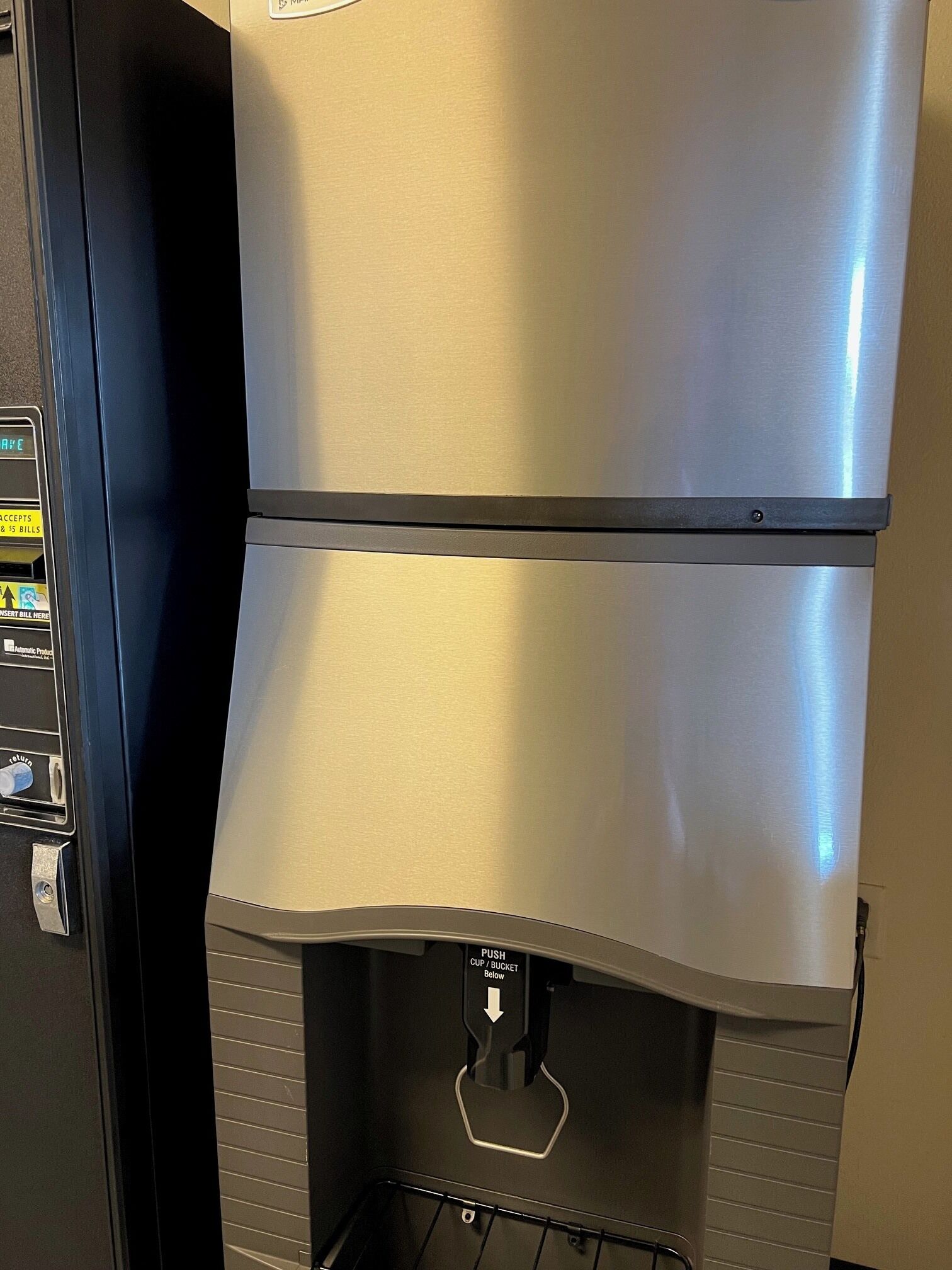 A commercial coffee machine with a push cup/bucket feature and a digital display.