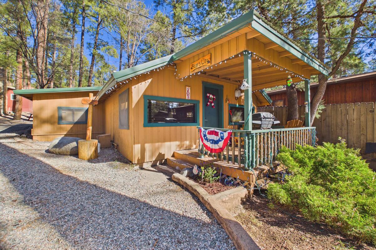 Une cabane en bois avec un porche, une pancarte indiquant qu’il s’agit d’un campement où l’on peut observer les ours, et un drapeau.