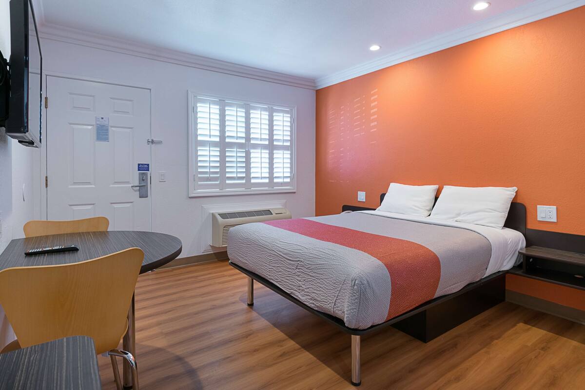 Une chambre d’hôtel avec un lit, une table et une chaise.
