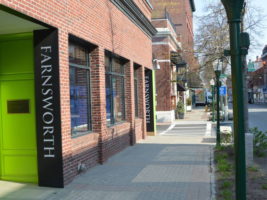 A brick building with large windows and a green door.