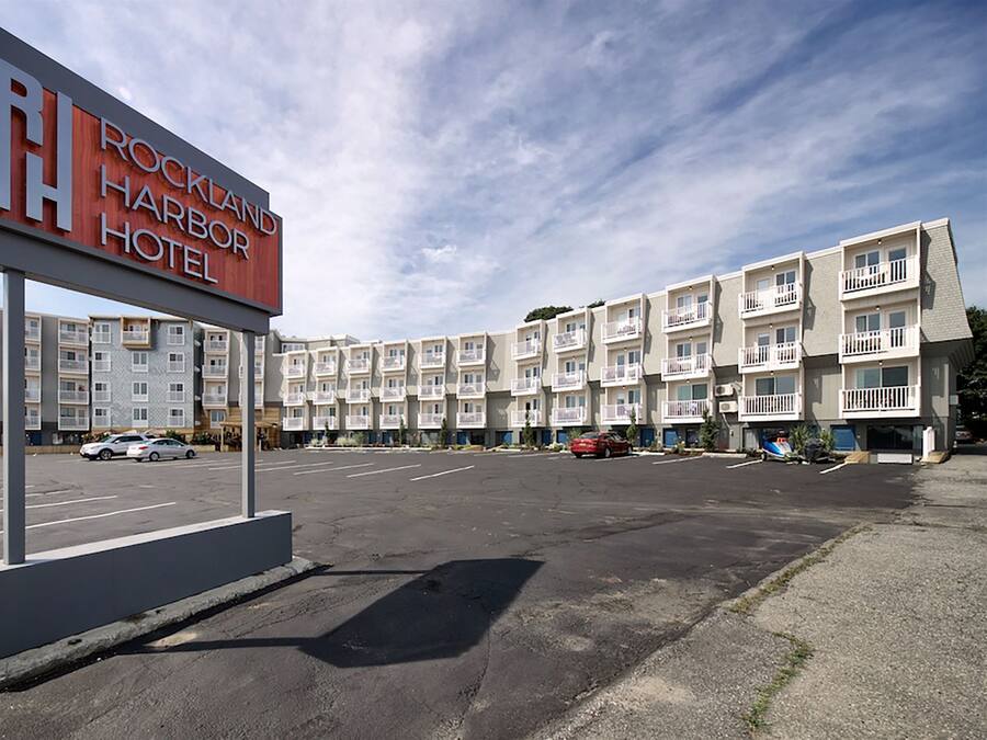 Hotel Rockland Harbor met een meerlaags gebouw, parkeerplaats en heldere lucht.