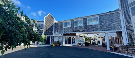 A building with a sign reading "GUEST LOFT" and a covered entrance area with potted plants.