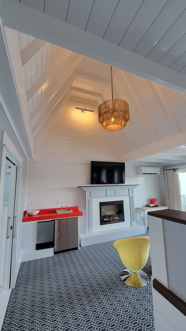 A modern kitchen with a built-in stove, a red countertop, and a stainless steel refrigerator.
