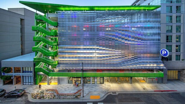 A modern building with a unique facade featuring a series of reflective panels and green staircases. - Nash Hotel (Berkeley)