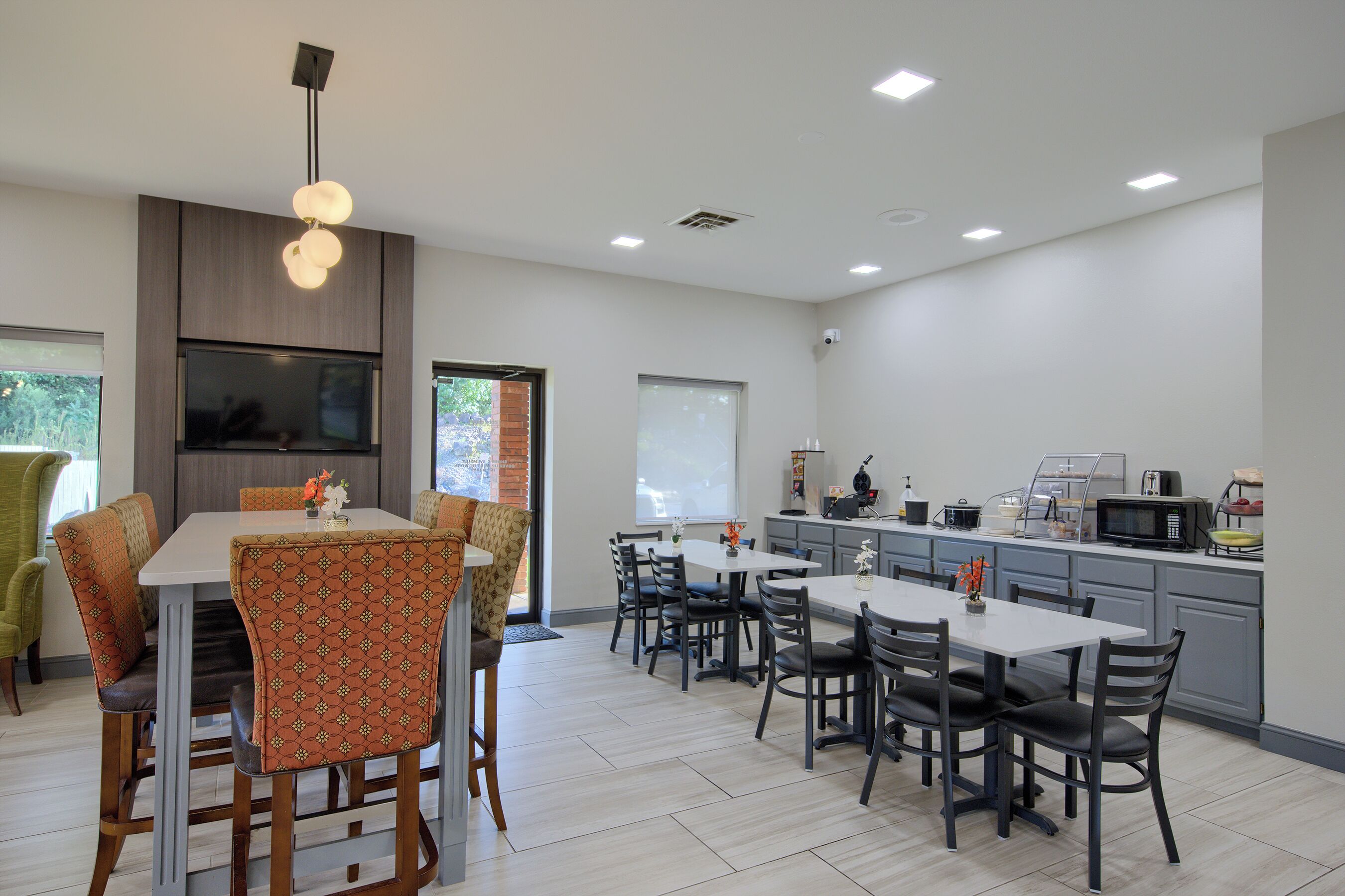 Una cocina moderna con comedor, que presenta una isla grande, electrodomésticos integrados y vistas al exterior.
